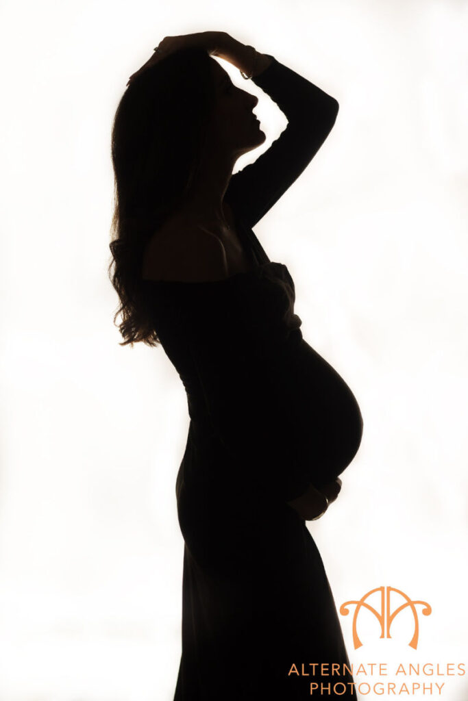 Silhouette portrait of pregnant mother during maternity photography sessionsession