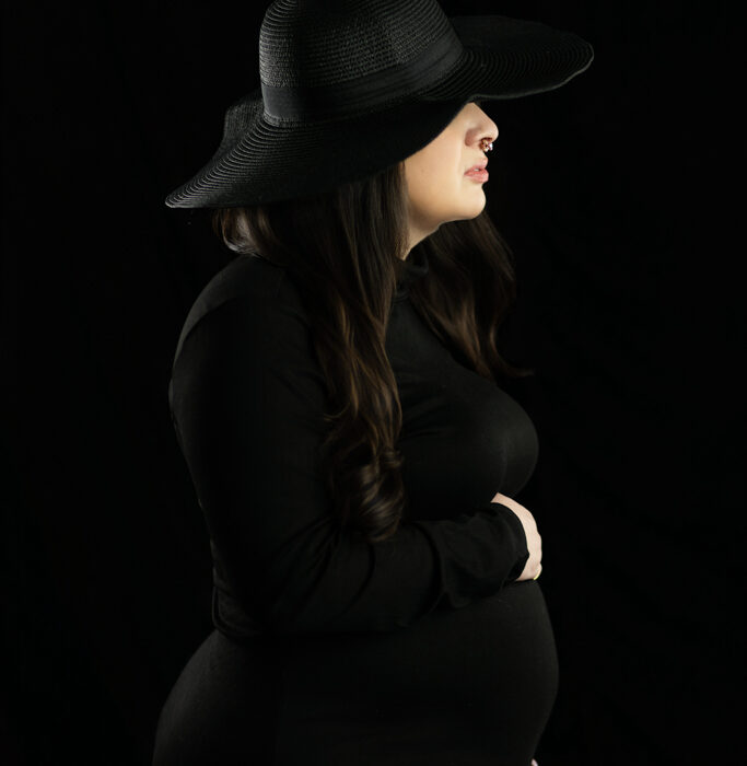 Black and white inspired maternity portrait of pregnant mother wearing wide brim hat