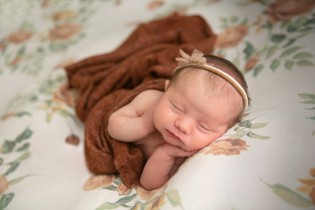 Black and white portrait of newborn baby girl resting peacefully during a photography session