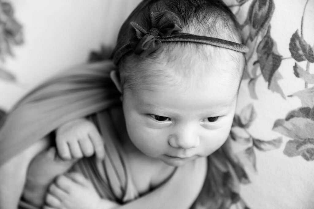 Black-and-white close-up portrait of sleeping newborn baby girl