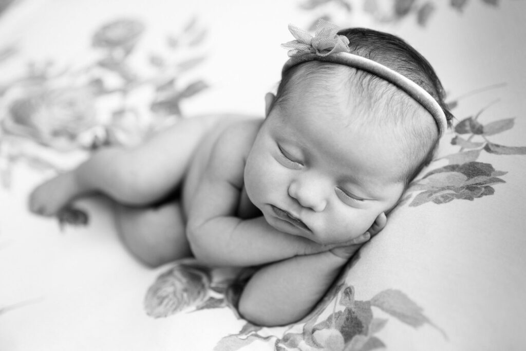Sleeping newborn wrapped in blue fabric against textured blue backdrop