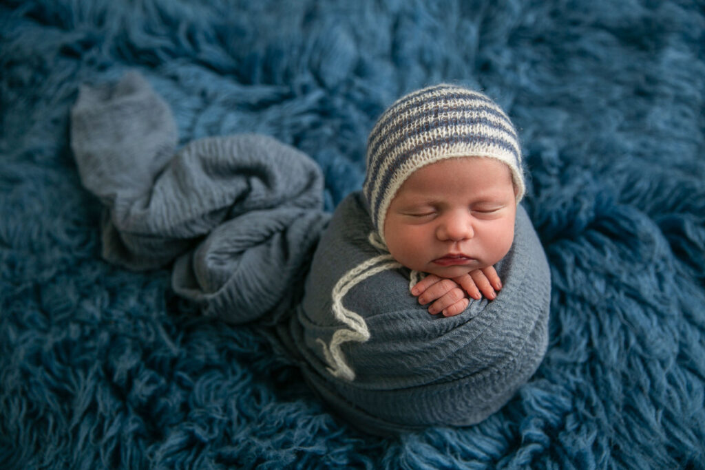 Close-up sleeping newborn wearing a knit cap during a professional photography session