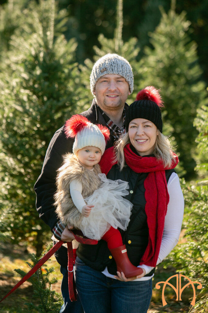 Parents and toddler during holiday tree farm family photography session