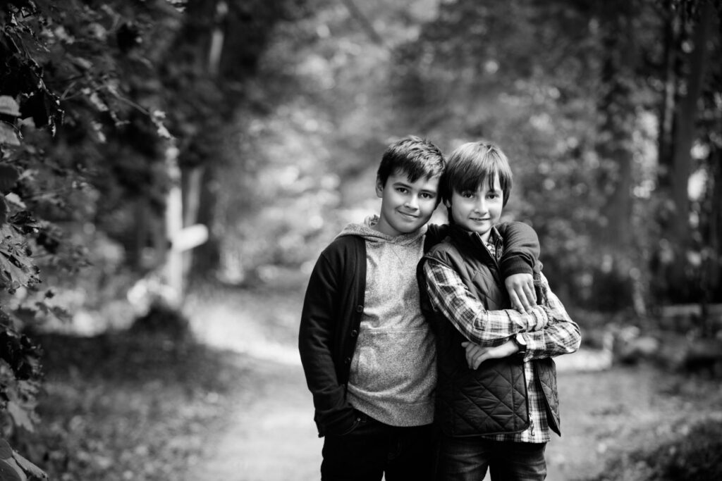 Black-and-white portrait of two brothers standing together outdoors.