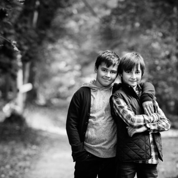 Black-and-white portrait of two brothers standing together outdoors.