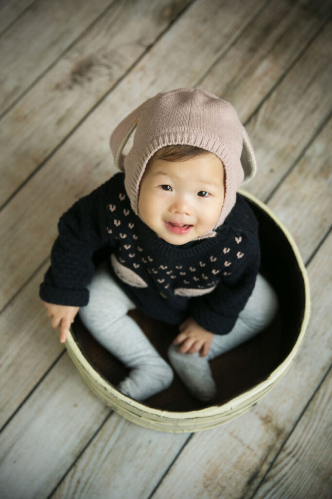 Baby girl sitting inside a bowl prop during a milestone photography session