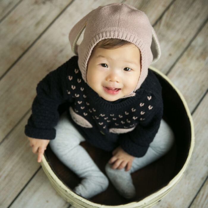 Baby girl sitting inside a bowl prop during a milestone photography session