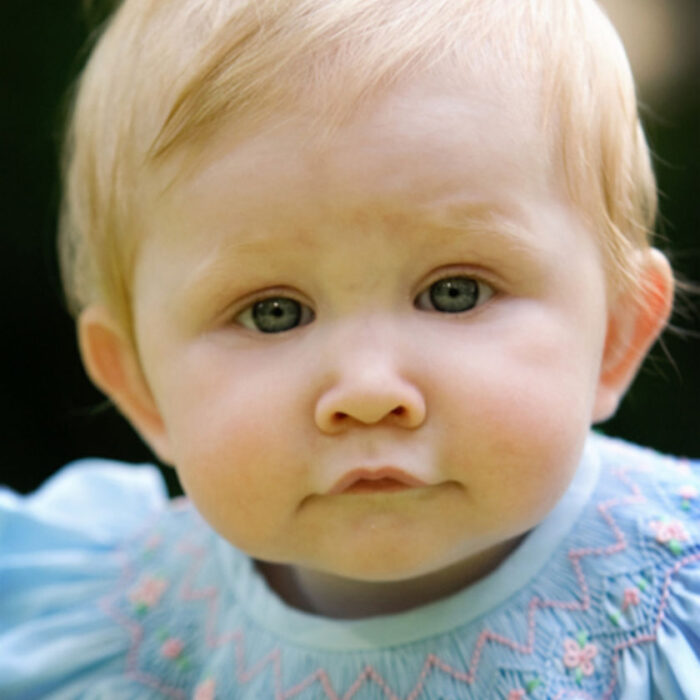 Close-up outdoor portrait of a baby girl with soft natural light and calm expression