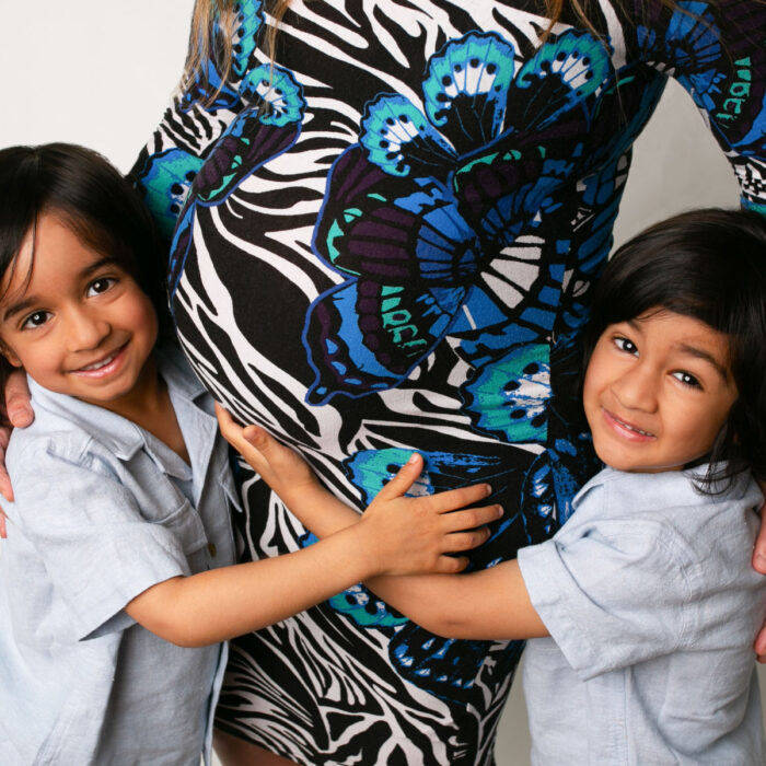 Young brothers hugging their mother's pregnant belly during a family maternity session