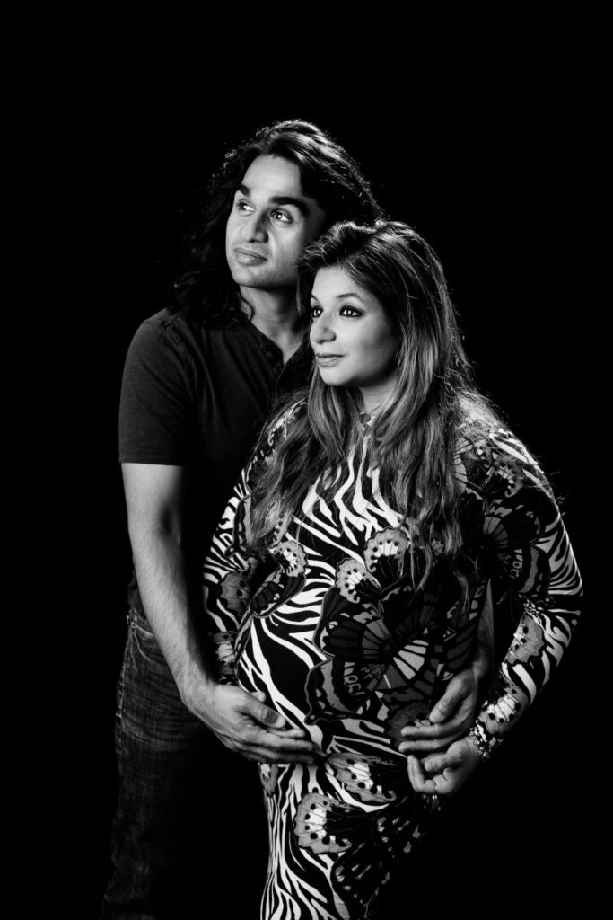 Expecting couple posing during a dramatic black-and-white maternity photography session