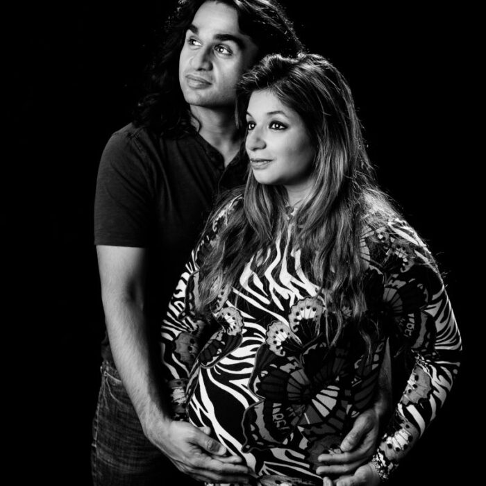 Expecting couple posing during a dramatic black-and-white maternity photography session