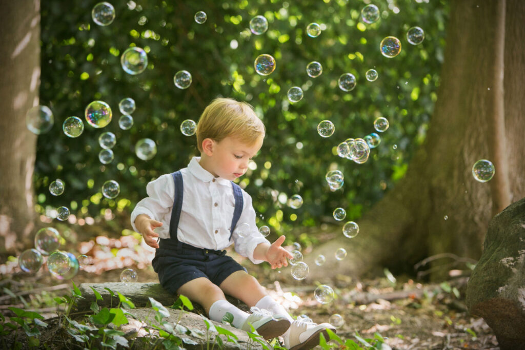 Young boy playing with bubbles during outdoor child portrait session