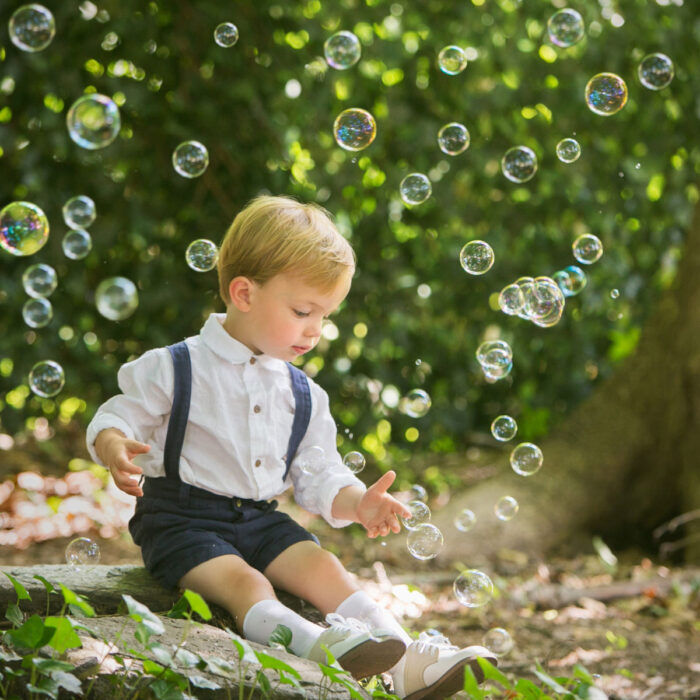 Young boy playing with bubbles during outdoor child portrait session