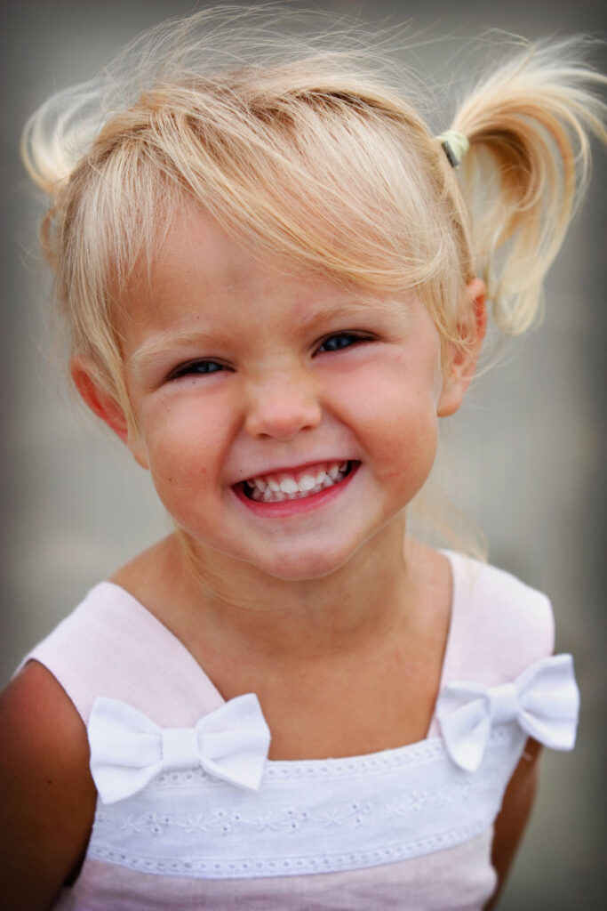 Close-up portrait of smiling young girl with pigtails.