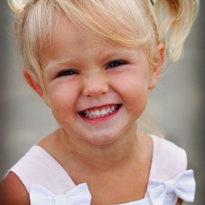 Close-up portrait of smiling young girl with pigtails.