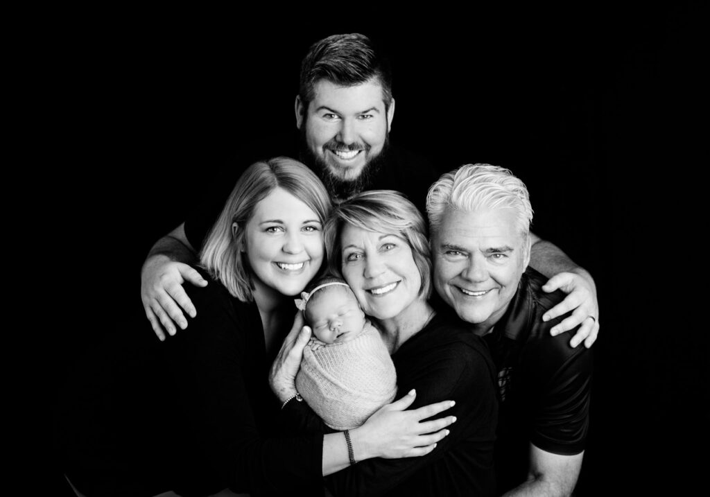Three generation family portrait with newborn baby in client's home but looking just like a photography studio