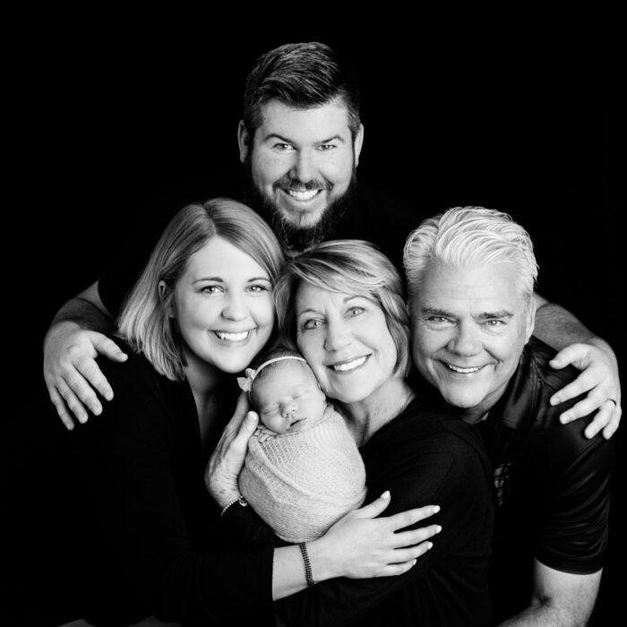Three generation family portrait with newborn baby in client's home but looking just like a photography studio