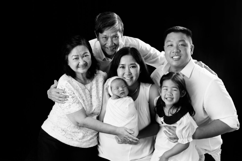 Multi generational family portrait with newborn baby and young child
