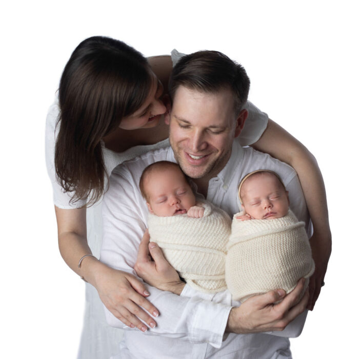 Parents holding newborn twins during studio newborn photography session