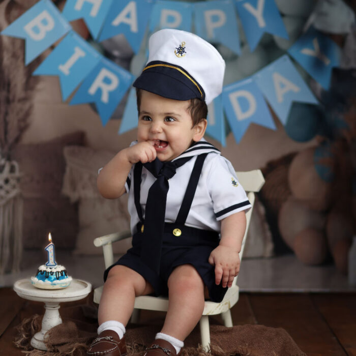 One year old baby in sailor outfit during nautical cake smash session