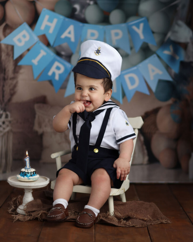 One year old baby in sailor outfit during nautical cake smash session