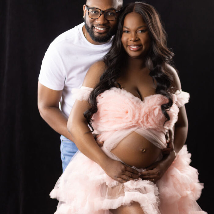 Pregnant mother wearing a soft pink gown during a studio maternity portrait session