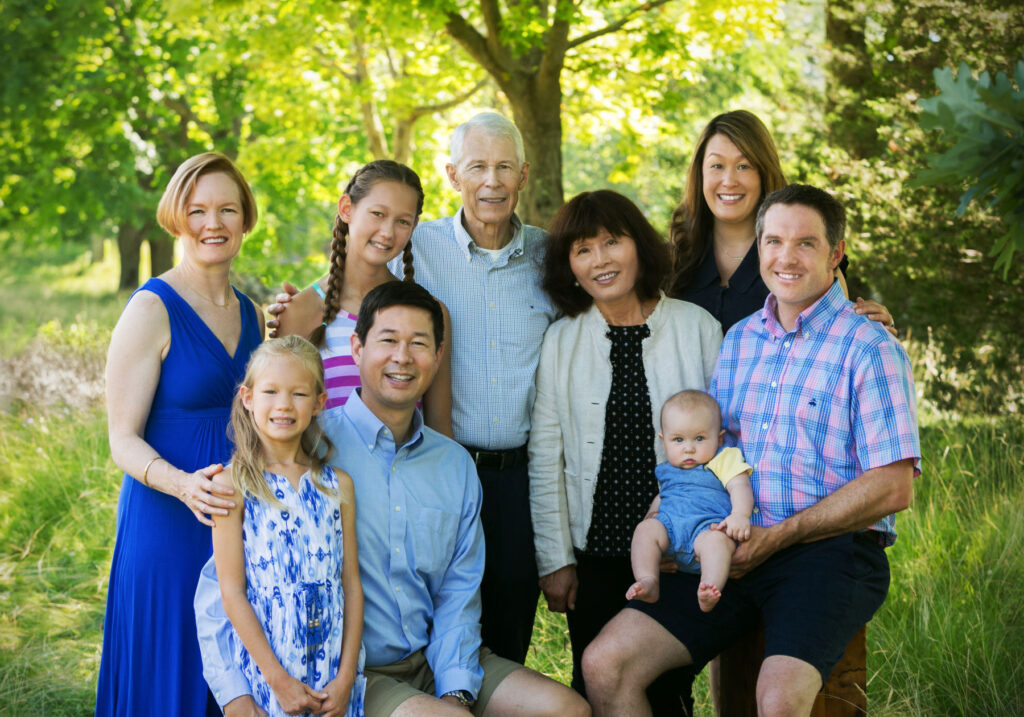 Three-generation family portrait outdoors with grandparents, parents and children