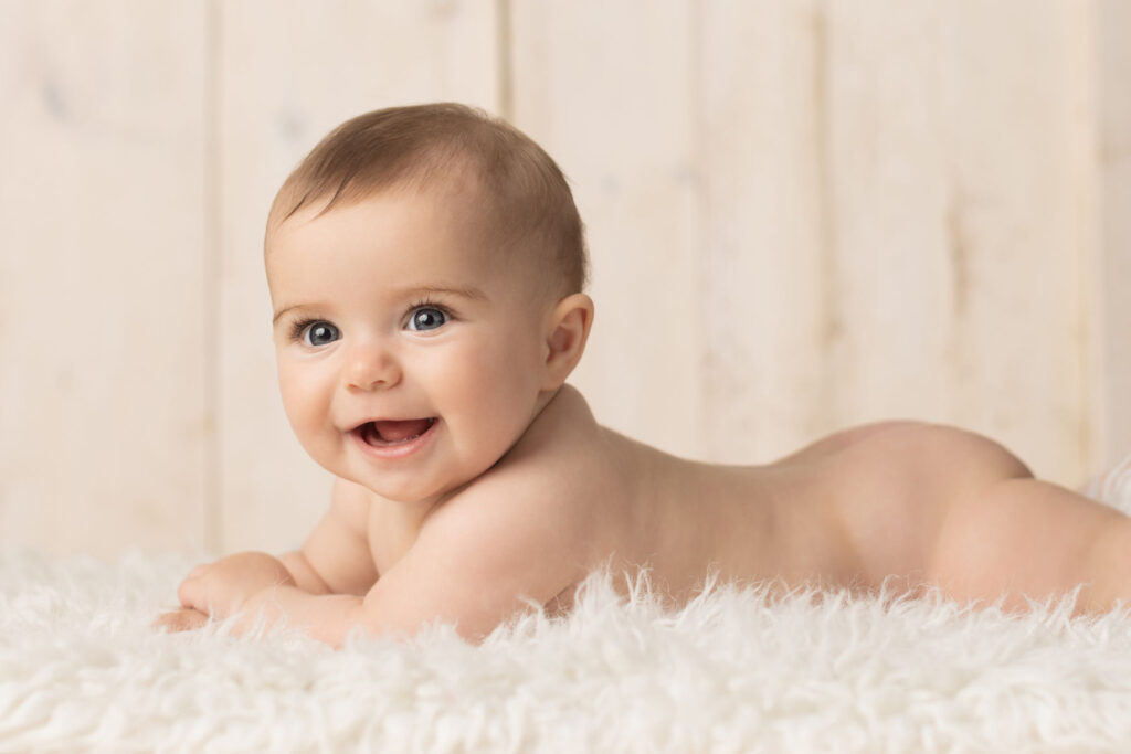 Smiling six month old baby during natural milestone photography session