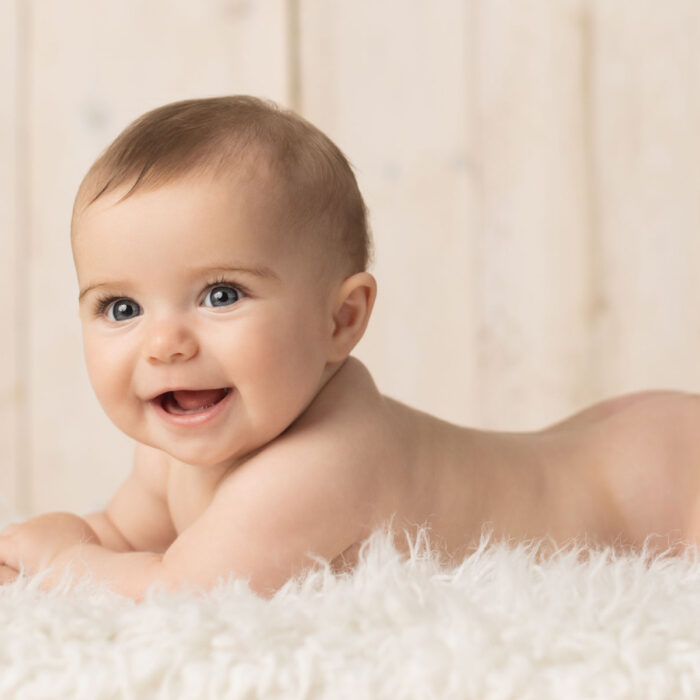 Smiling six month old baby during natural milestone photography session