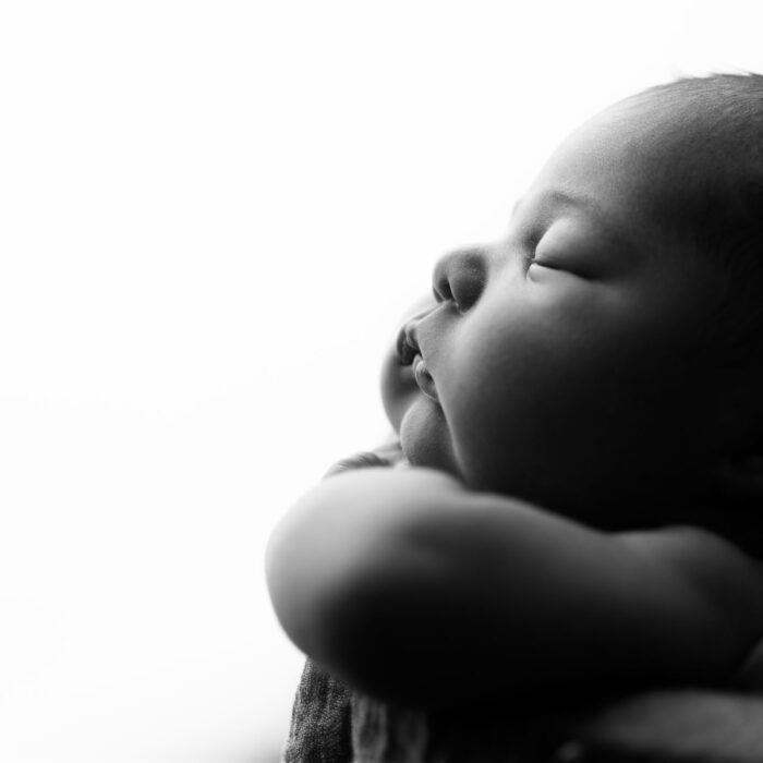 Close-up black and white profile portrait of a sleeping newborn baby