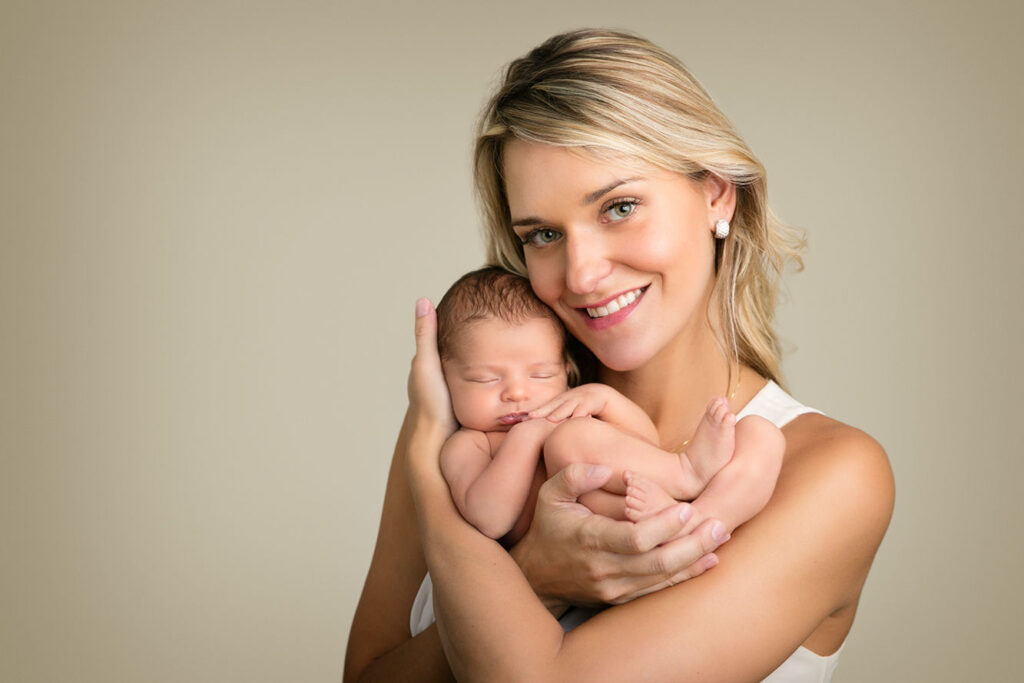 Mother holding her newborn baby during a studio newborn photography session