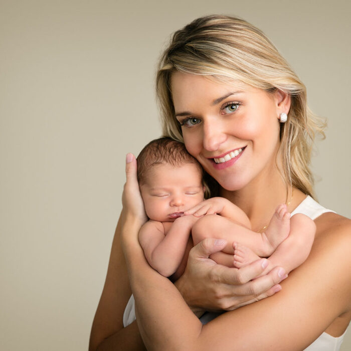 Mother holding her newborn baby during a studio newborn photography session
