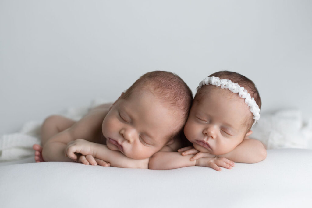 Twin newborn babies sleeping together during a studio portrait session