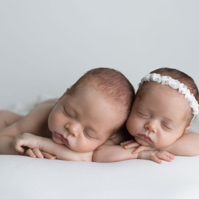 Twin newborn babies sleeping together during a studio portrait session