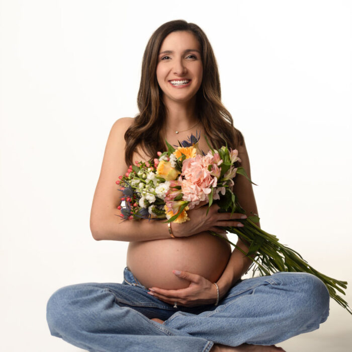 Pregnant mother holding a bouquet of flowers during a studio maternity portrait