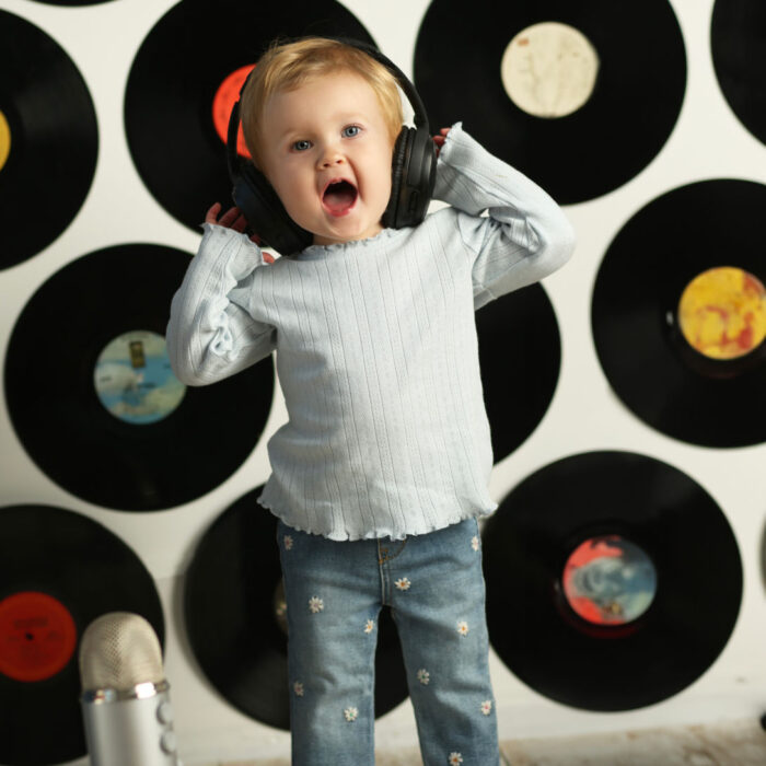 Baby wearing headphones in music-themed Watch Me Grow portrait session.