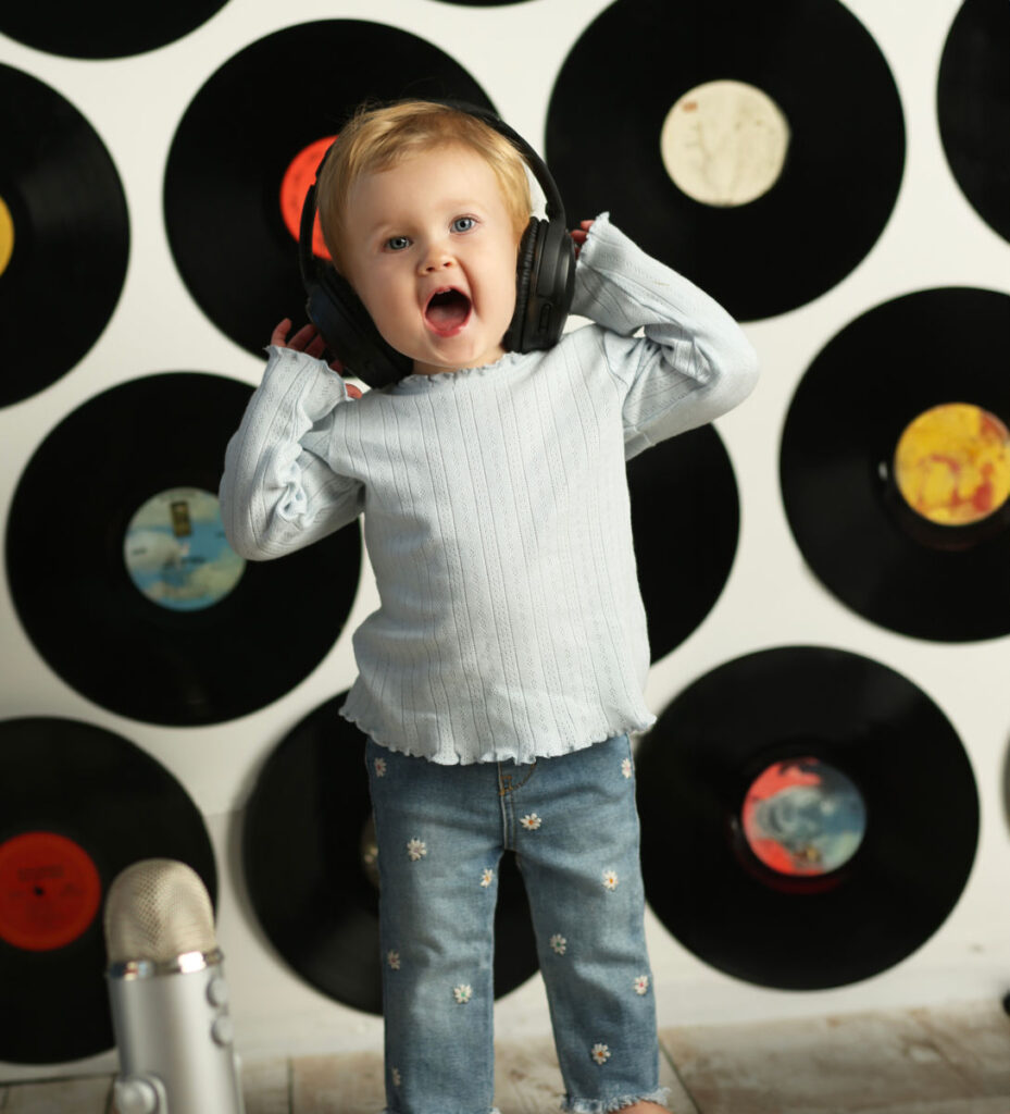 Baby wearing headphones in music-themed Watch Me Grow portrait session.