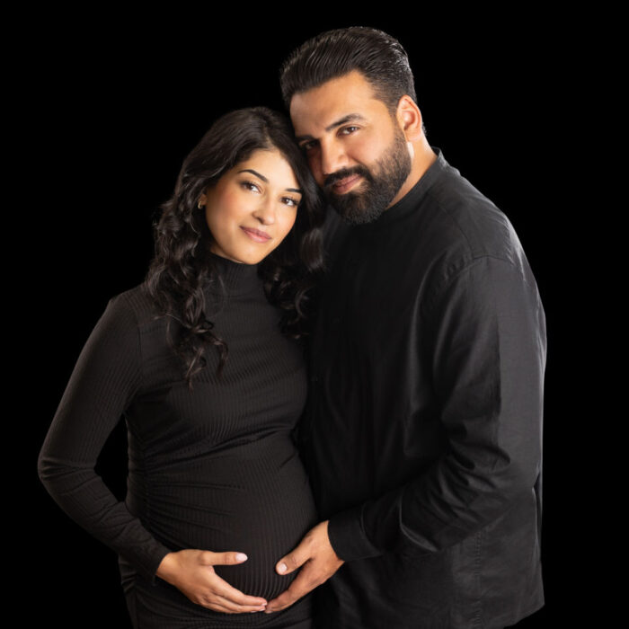 Expecting couple posing together during a studio maternity photography session