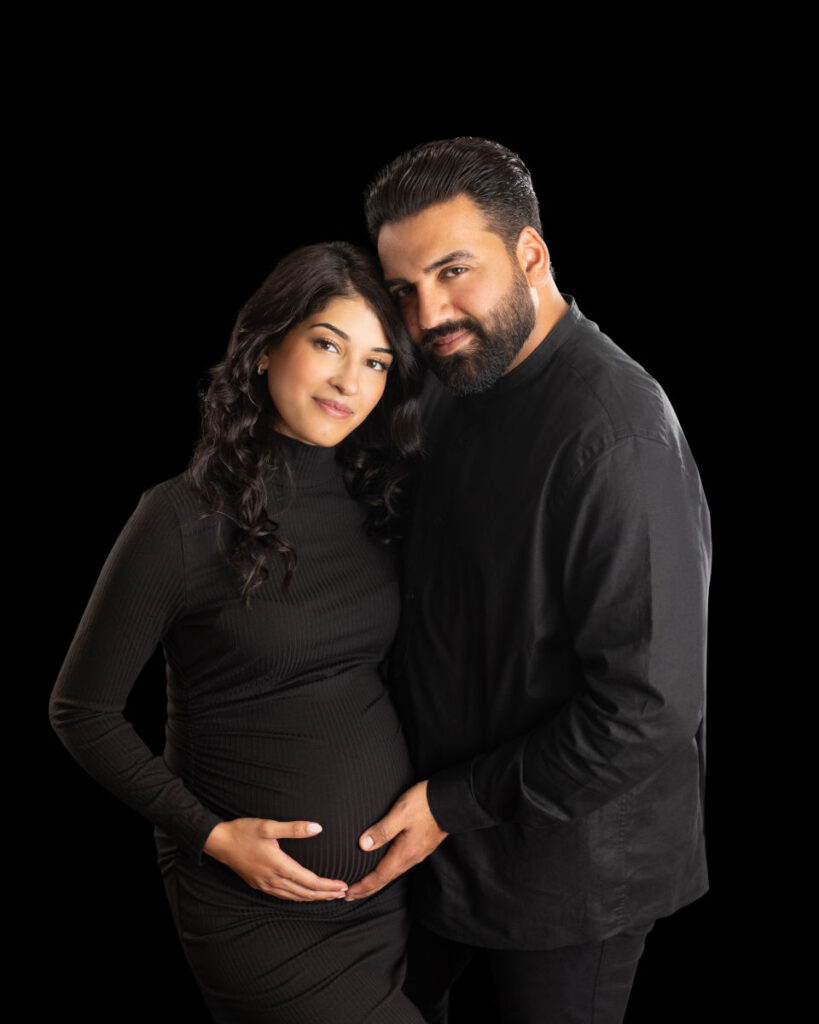 Expecting couple posing together during a studio maternity photography session