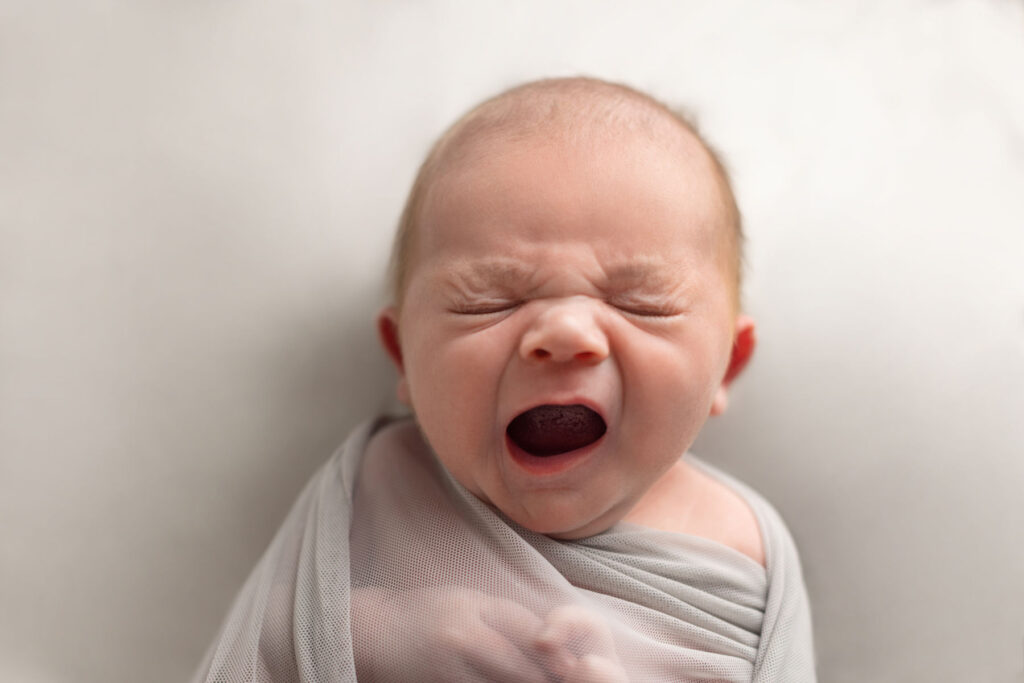 Newborn baby yawning during a natural studio portrait session