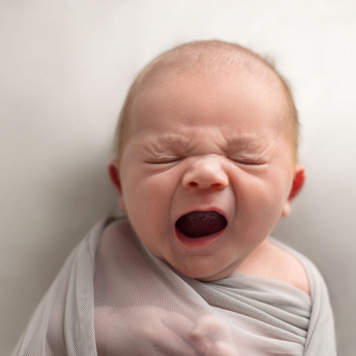 Newborn baby yawning during a natural studio portrait session