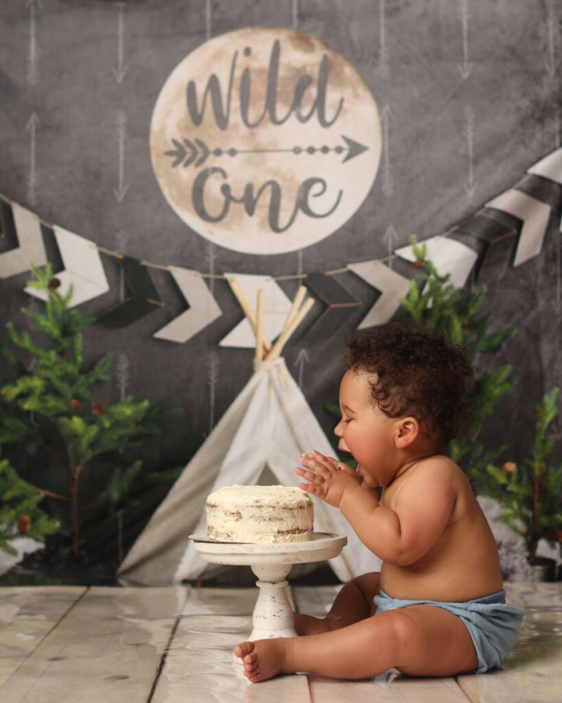 One year old baby enjoying cake smash during Wild One first birthday session