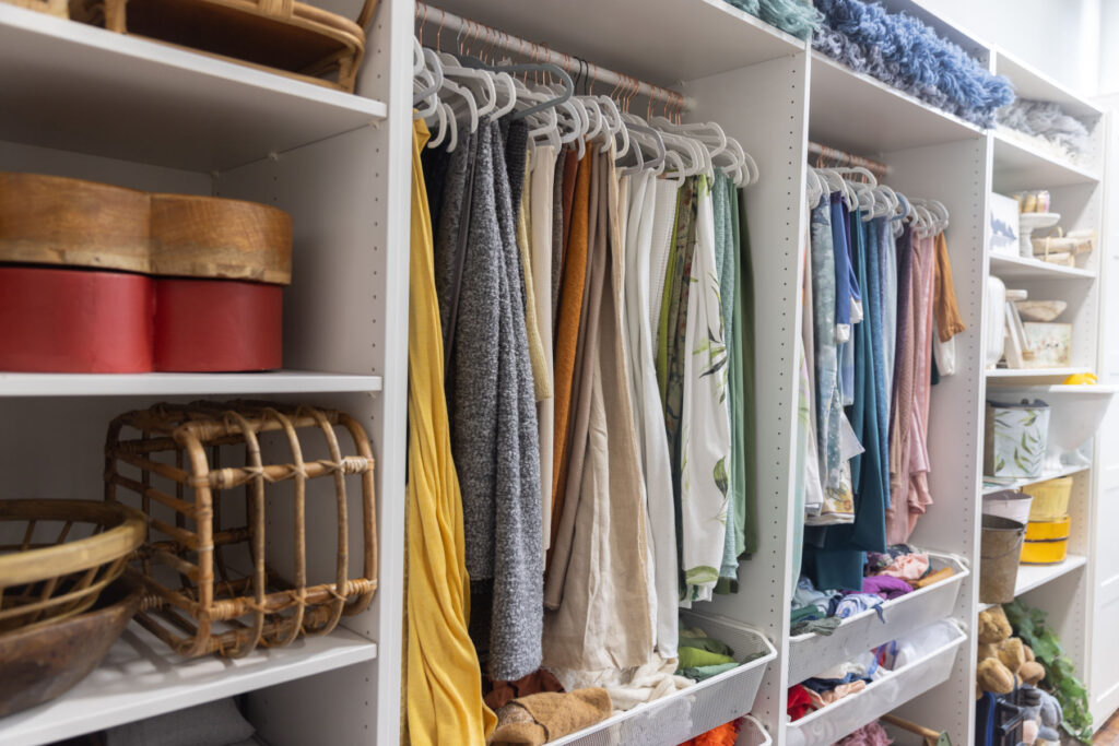 Organized collection of newborn wraps, dresses and portrait session wardrobe pieces at Alternate Angles Photography studio