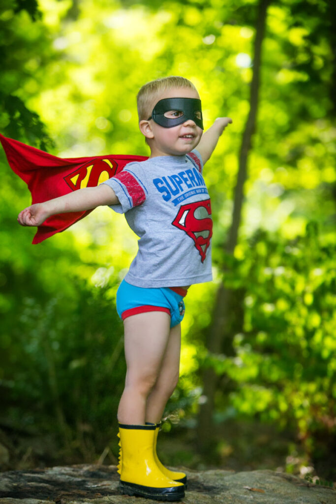 Young child dressed as a superhero during an imaginative outdoor portrait session