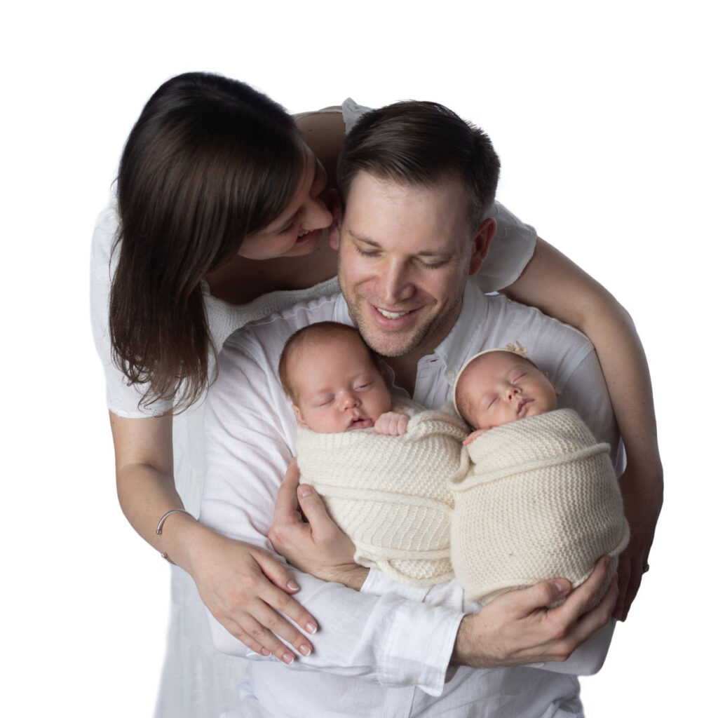 Parents holding newborn twins during a family studio portrait session
