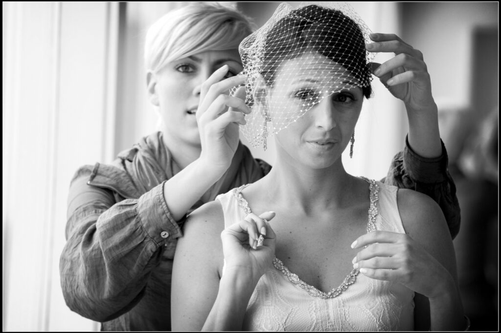 Bride having her birdcage veil adjusted while getting ready for her wedding at Belle Mer in Newport Rhode Island