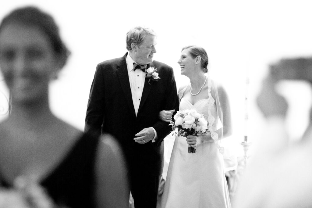 Bride smiling with her father at the top of the aisle before walking into the wedding ceremony