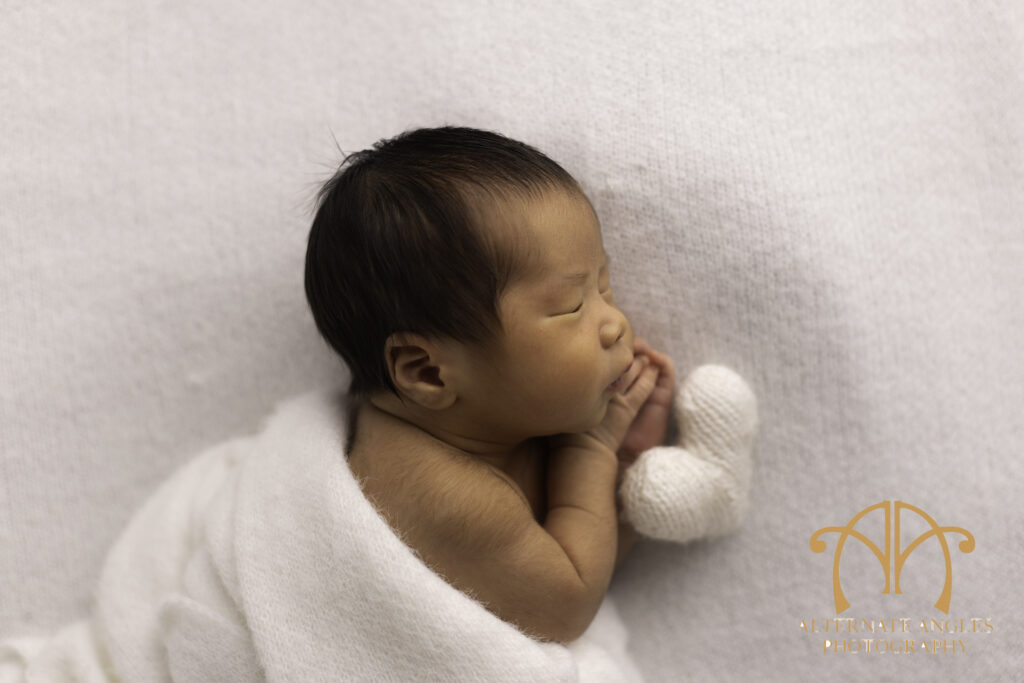 Japanese newborn baby posed with white heart prop during Boston newborn session